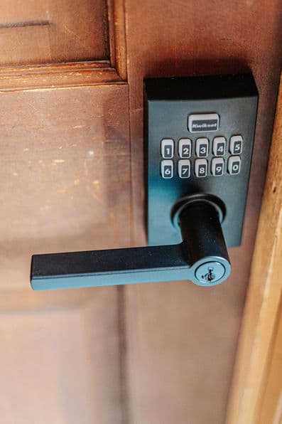 A close up of the entryway door handle with coded lock.